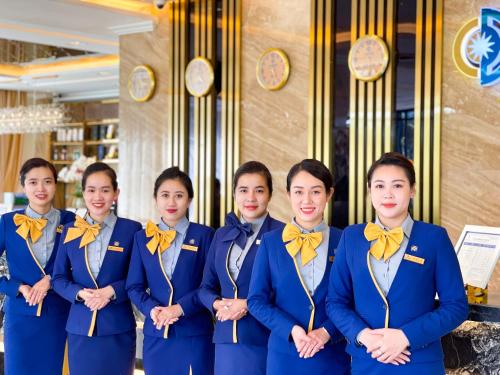 a group of women in blue uniforms with yellow bows at Sandals Vista Hotel in Bao Loc