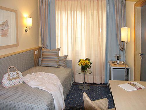 a hotel room with two beds and a table at City Hotel in Schopfheim