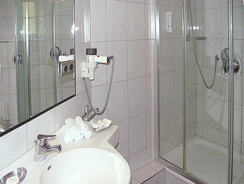 a bathroom with a shower and a toilet and a sink at City Hotel in Schopfheim