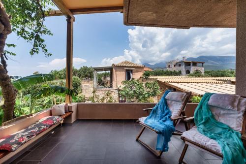 a view from the balcony of a house with two chairs at Malsova-Home in Kotrónion