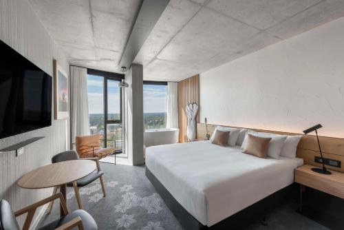 een hotelkamer met een bed, een bureau en een televisie bij Vibe Hotel Adelaide in Adelaide