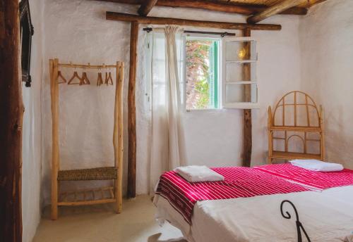 a bedroom with a bed and a window at Khanfous Retreat in Asilah