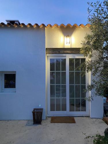 a white house with a sliding glass door at Cor de Azeitona in Aldeia do Mato