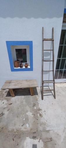 a ladder and a bench next to a wall with a window at Cor de Azeitona in Aldeia do Mato