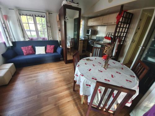 un salon avec une table et un canapé bleu dans l'établissement Mobil Home, à Sainte-Eulalie-en-Born