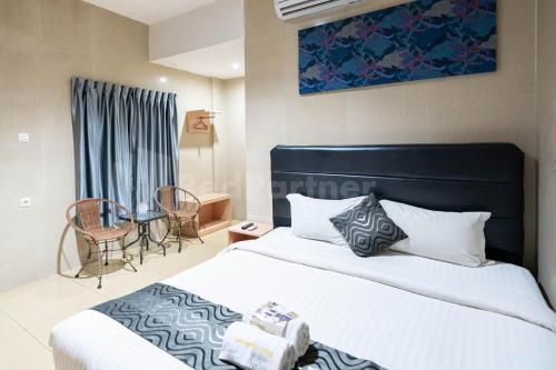 1 dormitorio con 1 cama y 1 mesa con sillas en New Gentala Hotel Mitra RedDoorz, en Medan