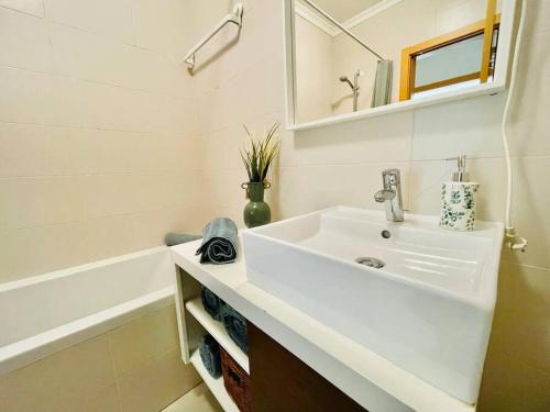 La salle de bains blanche est pourvue d'un lavabo et d'une baignoire. dans l'établissement PêraDoce - Beach 150m - Terrace - Private Parking, à Armação de Pêra
