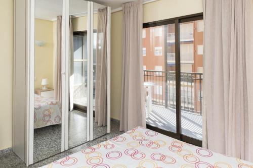 a bedroom with a bed and a balcony at Provence, 5º-18 in Cullera