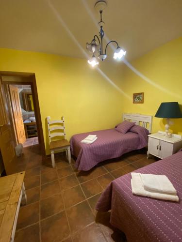 1 dormitorio con 2 camas, mesa y lámpara en El Magnoliio, en Santa Cruz de Pinares
