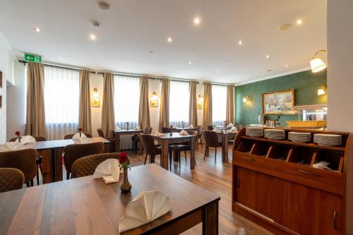 uma sala de jantar com mesas e cadeiras num restaurante em Jupa's Hotel em Dusseldorf