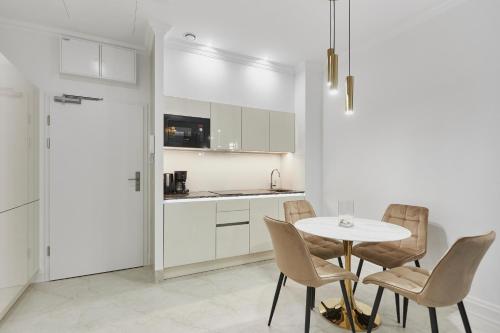 a kitchen and dining room with a table and chairs at Seaside Garden by Baltic Home in Świnoujście