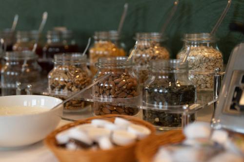 a table with jars of seeds and a bowl of nuts at Jupa's Hotel in Düsseldorf