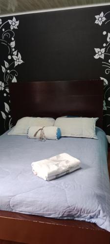 a bed with a wooden headboard and white sheets and pillows at Dulce sueños baño compartido in Chía