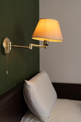 a lamp sitting next to a bed with a pillow at Jupa's Hotel in Düsseldorf