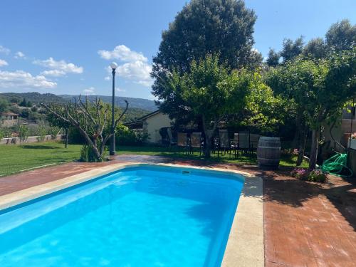 a swimming pool in a yard with trees at Casa Rural Entrepinos in Avila