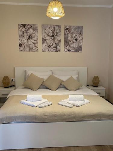 a bedroom with a bed with two towels on it at Airport Alexandra Apartments in Surčin