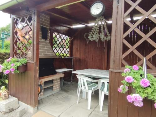 d'une terrasse avec une table et une horloge. dans l'établissement Ubytování U Andílka, à Horní Planá