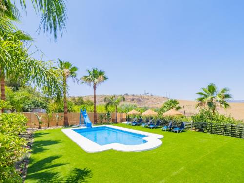 a backyard with a swimming pool and green grass at Cubo's Lemon House in Cártama