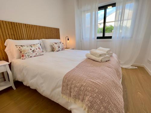a bedroom with a large white bed with towels on it at Balnea O Pazo in Mondariz-Balneario