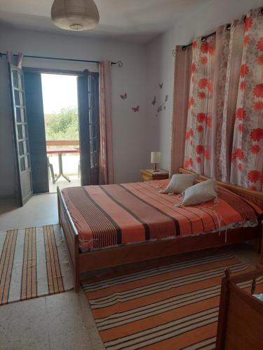 a bedroom with a large bed and a large window at Appart Gyptis Résidence Chahrazad in Sfax