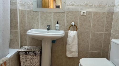 ein Badezimmer mit einem Waschbecken, einem WC und einem Spiegel in der Unterkunft Apartamento con vistas panorámicas al mar, golf, puerto deportivo in Almerimar