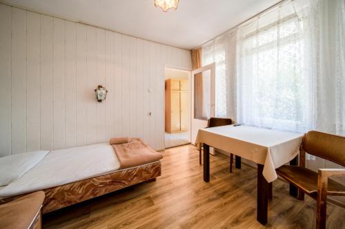 a bedroom with a bed and a table and a window at OW Gromada Pod Topolami in Międzyzdroje