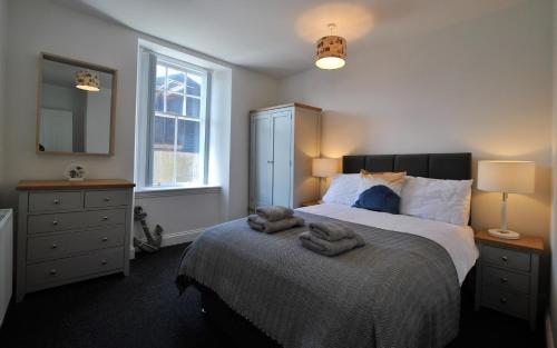 a bedroom with a large bed with towels on it at May View in Pittenweem