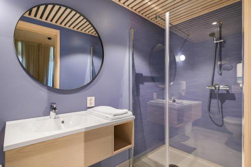 a bathroom with a sink and a shower and a mirror at RS Noatun in Horten