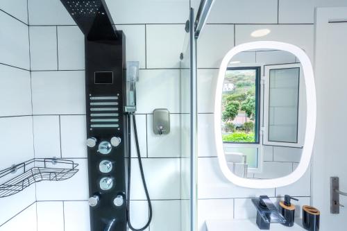 a bathroom with a shower and a mirror at Mateus House - Porto da Cruz Center in Porto da Cruz