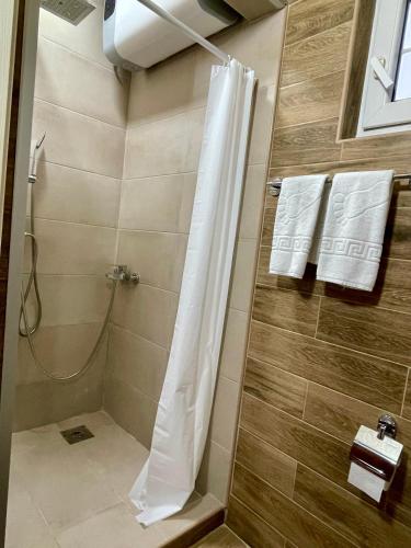 a shower with a white shower curtain in a bathroom at Airport Apartments Alexandra in Surčin