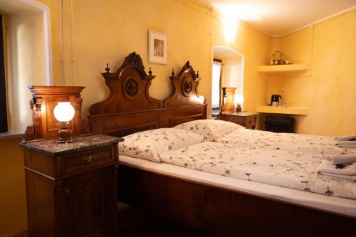 a bedroom with a large bed with a wooden headboard at Škerlj Wine Estate in Tomaj
