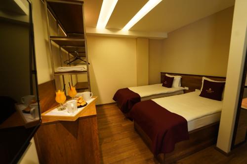 a hotel room with two beds and a table at Monarch Hotel in Prizren