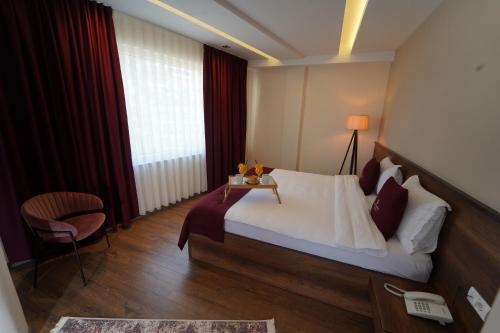 a hotel room with a bed and a chair at Monarch Hotel in Prizren