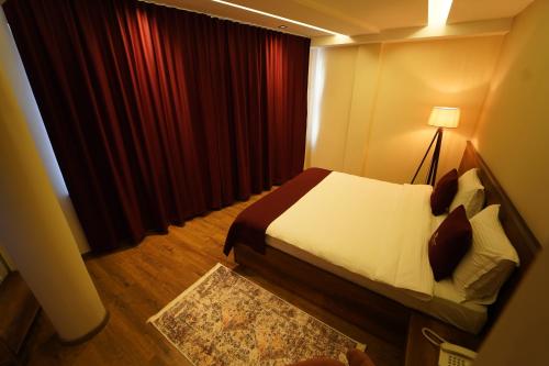 a hotel room with a bed and a window at Monarch Hotel in Prizren