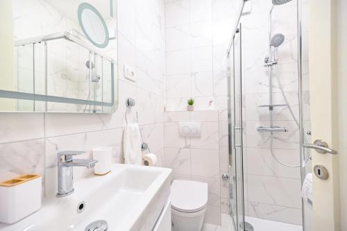 uma casa de banho branca com um lavatório e um chuveiro em Mediterano Zara em Zadar