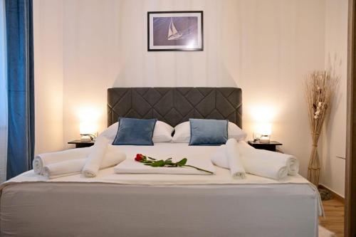 um quarto com uma grande cama branca com travesseiros azuis em Mediterano Zara em Zadar