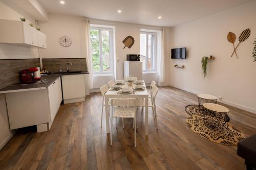 kuchnia i jadalnia ze stołem i krzesłami w obiekcie LD-Location Hôtel w mieście Montluçon