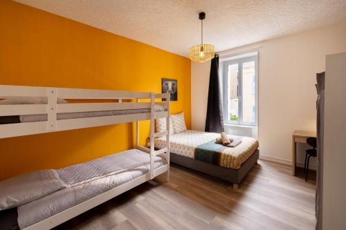 two bunk beds in a room with a yellow wall at LD-Location Hôtel in Montluçon