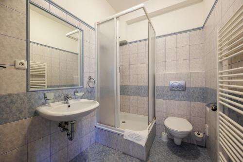 a bathroom with a sink and a toilet and a shower at Pension U Golfu Cihelny in Karlovy Vary