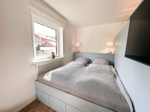 1 dormitorio con 1 cama grande y ventana en Eisvogel, en Oberstaufen