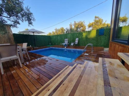 a backyard with a pool and a wooden deck at Antik Tiny House in İznik
