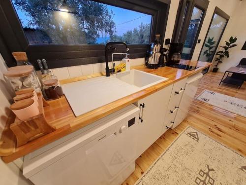 encimera de cocina con fregadero y ventana en Antik Tiny House, en İznik