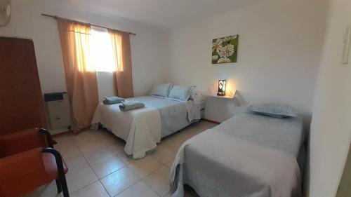 ein Hotelzimmer mit 2 Betten und einem Fenster in der Unterkunft CASA EN JUANA KOSLAY San Luis con pileta in San Luis
