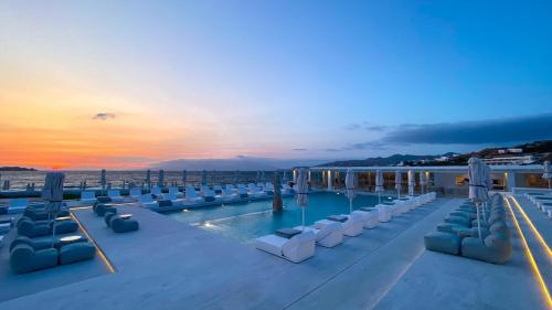 a pool on the roof of a building with chairs at Mykonos Bay Resort & Villas in Mikonos