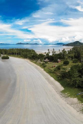 a dirt road with a view of the ocean at La Tranquilidad Twin Beach Resort in Dipnay