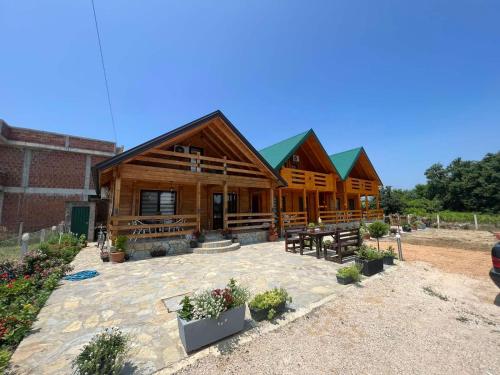 a log cabin with benches and tables in front of it at Lindi & Learti Apartments in Donji Štoj