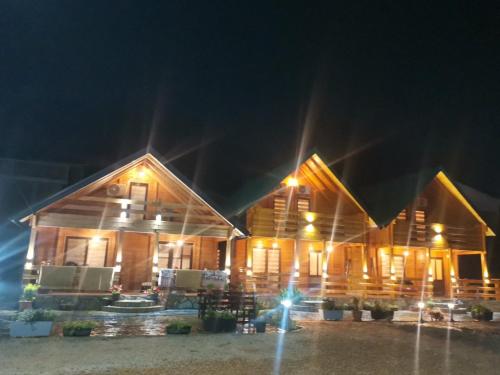 a wooden house at night with lights on it at Lindi & Learti Apartments in Donji Štoj