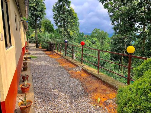 a walkway next to a fence with plants at New Araniko Resort (P) Ltd in Chautara
