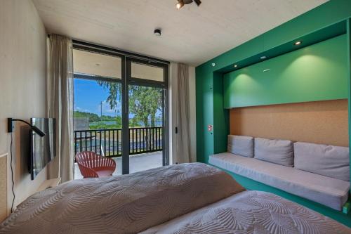 um quarto com uma cama, um sofá e uma varanda em RS Noatun em Horten