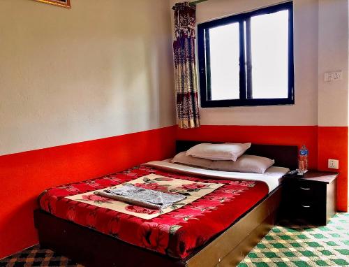 a bed in a room with a red wall at New Araniko Resort (P) Ltd in Chautara